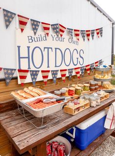 a picnic table with hot dogs and buns on it