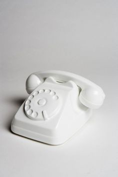 an old fashioned white telephone on a white surface