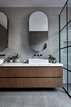 a bathroom with two sinks and mirrors on the wall