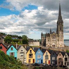 a row of colorful houses with a church in the background