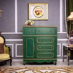 a green cabinet with gold trim in a living room