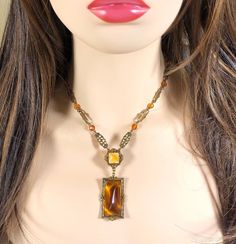 Beautiful Czechoslovakian style 1930-1940 amber colorded glass pendant on a detailed gold tone link chain with amber colorded crystal beads. Dress up or dress down this stunning piece; unmarked. Collectible Vintage Amber Jewelry, Antique Brown Necklace For Collectors, Antique Amber Pendant Necklaces, Antique Amber Pendant Necklace, Antique Gold Beaded Vintage Necklace, Vintage Beaded Antique Gold Necklace, Vintage Yellow Brass Jewelry, Vintage Amber Beaded Necklace, Vintage Baltic Amber Jewelry For Formal Occasions