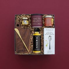 an open gift box containing various items such as jam, salted peanuts and other condiments