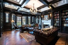 a living room filled with lots of furniture and bookshelves in front of a fire place