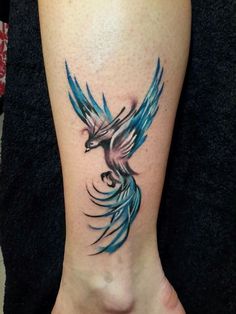 a tattoo on the leg of a woman's foot with a blue and black bird