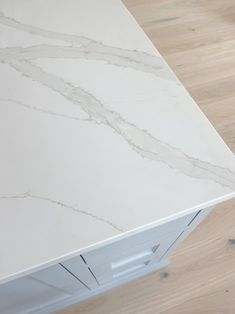 a white counter top sitting on top of a wooden floor