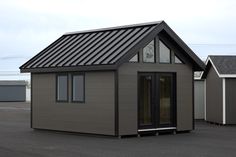 a small house with a metal roof and windows