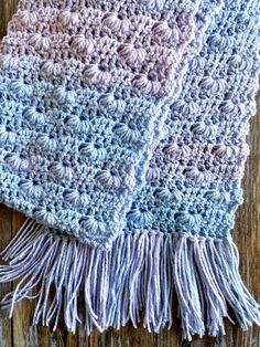 a crocheted blanket on top of a wooden table