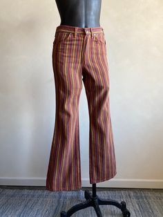 "Beautiful 70s Striped Denim Jeans by Wrangler. Striped multicolor pattern design made from cotton fibers in the USA. Pants have a zipper fly closure. Denim is super soft! Condition overall is great with no noted flaws. No rips, tears, or stains. Please see all photos for details.  Refer to measurements below to ensure a proper fit (modeled on a size small mannequin) 14\" across waist 16\" across hip 11\" rise 30\" inseam" 70s Fashion Colorful, 70s Style Jeans, Multicolor Full Length Jeans For Fall, High Rise Multicolor Cotton Pants, Multicolor High Rise Cotton Pants, Multicolor High-rise Cotton Pants, Multicolor Mid-rise Cotton Bottoms, 70s Inspired Cotton Bottoms For Fall, Multicolor Cotton Mid-rise Bottoms