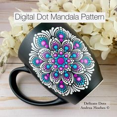 a black coffee mug with an intricate design on it and flowers in the background that reads, digital dot amanda pattern