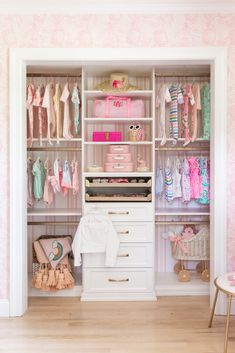 a white closet filled with lots of baby clothes