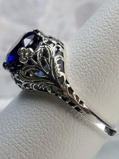 blue sapphire solitaire ring with swirl antique floral sterling silver filigree Victorian Sapphire Ring, Elegant Round Sapphire Filigree Ring, Elegant Round Sapphire Ring With Filigree, Classic Filigree Ring With Intricate Design, Victorian Sapphire Ring With Diamond Cut, Vintage Silver Solitaire Sapphire Ring, Vintage Silver Sapphire Solitaire Ring, Elegant Silver Sapphire Ring With Filigree, Exquisite Silver Filigree Ring With Round Cut