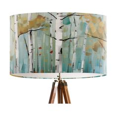 a table lamp with a blue and white shade on it's base, featuring birch trees