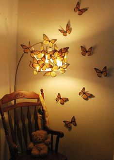 a teddy bear sitting in a rocking chair next to a wall with butterflies on it