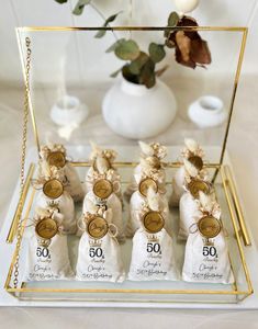 small bags of chocolates are on display in a glass case with gold trimming