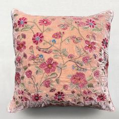 a pink pillow with flowers and leaves on it