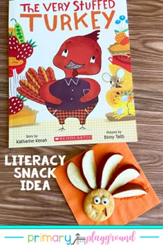 the very stuffed turkey is next to a book on a table with an orange napkin