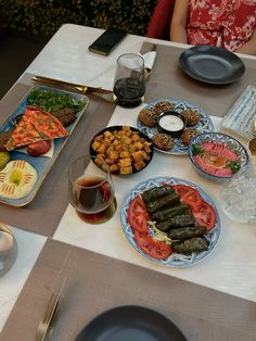 a table topped with plates and bowls filled with food