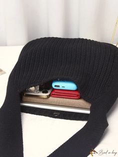 a cell phone is sitting in the pocket of a purse on top of a table