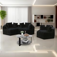 a living room filled with black couches next to a white coffee table and potted plant