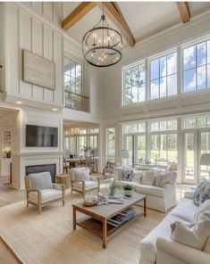 a living room filled with white furniture and large windows