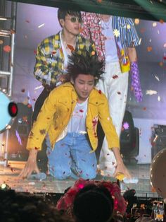 a group of people on stage with confetti falling from the air in front of them