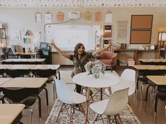 a woman sitting at a table in front of a whiteboard with flowers on it