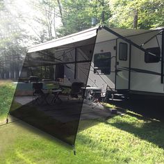 an rv is parked in the grass near some trees