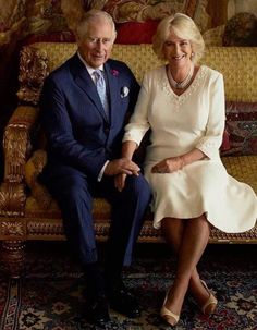 an older man and woman sitting on a couch