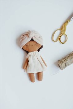 a doll with a turban and a spool of thread next to it