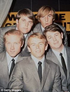 four men in suits and ties posing for a photo