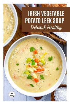 two bowls filled with potato leek soup on top of a wooden table next to bread