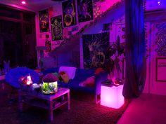 the living room is lit up with purple lighting and decorations on the walls, along with plants