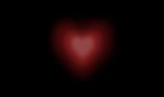 a red heart shaped object in the dark