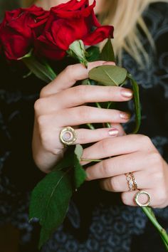 a woman holding roses with two rings on her fingers