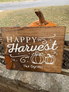 a wooden sign that says happy harvest and the gourds are in front of it