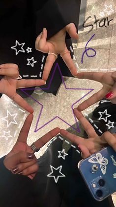 several people are holding their hands in the shape of a star with stars painted on them