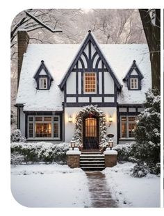 a house covered in snow with steps leading to it and lights on the front door