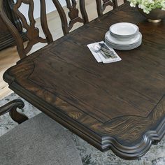 a wooden table with plates and silverware on it