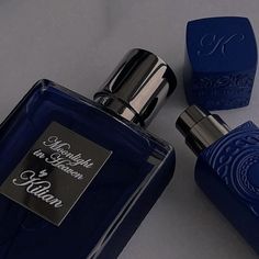 two bottles of blue perfume sitting next to each other