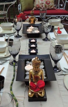 a table set with plates, silverware and candles on top of the placemats