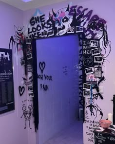 a bathroom with graffiti on the walls and door to another room that has been decorated in black and white