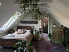 a bed sitting under a window next to a plant filled wall in a bedroom on top of a rug