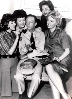 an old black and white photo of four people sitting on a couch