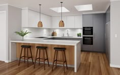 an empty kitchen with three stools in front of the counter and two lights on the ceiling