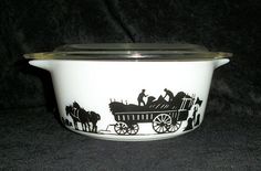 a casserole dish with black silhouettes of people riding in a horse drawn carriage