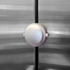 a metal door with a white button on it