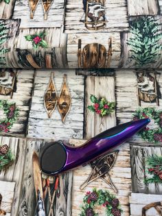 a pair of purple scissors sitting on top of a wooden table next to christmas decorations