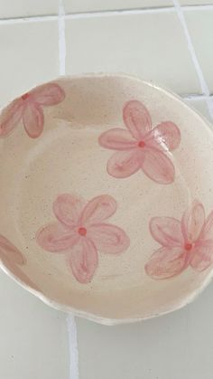 a bowl with pink flowers painted on it