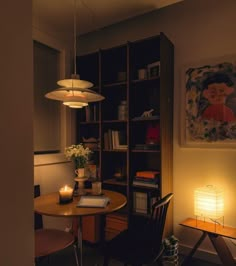 a room with a table, chair and bookshelf